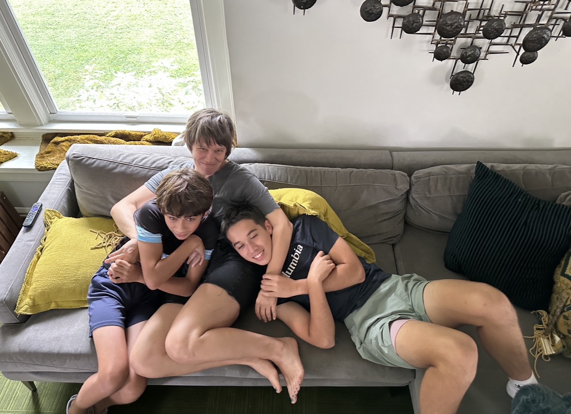Mom on the couch with both boys piled on top of her